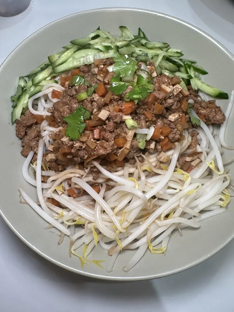 Dry noodles topped with minced pork sauce, cucumber, and bean sprouts